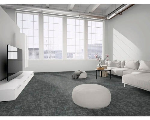 Modernes Loft-Wohnzimmer mit dunkelgrauen Teppichfliesen, weißem Sofa, Sitzpuffern und großen Fenstern mit Stadtblick.