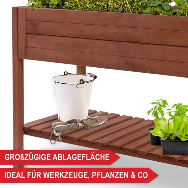 Hochbeet aus Holz mit Ablagefläche für Gartenwerkzeug, einen Eimer und Setzlinge.