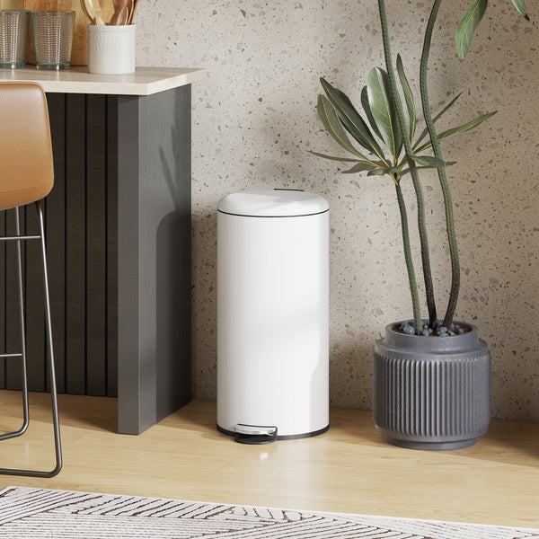 Weißer Treteimer in einer hellen Küche neben einer Zimmerpflanze.