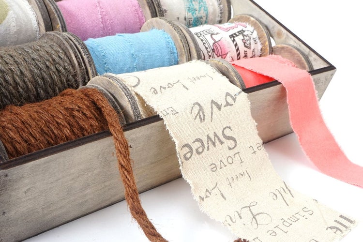 Dekorative Bänder und Kordeln in einer Holzbox für Bastelarbeiten