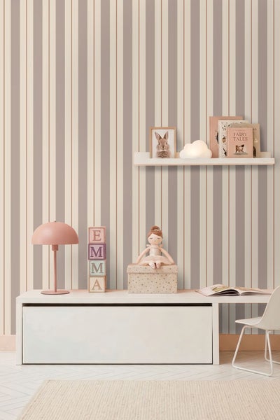 Kinderzimmer mit vertikal gestreifter Tapete, weißem Sideboard, Wandregal, Tischlampe und Spielzeug.