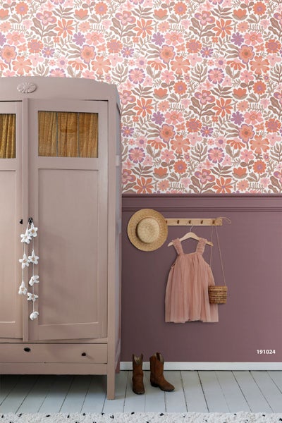 Vliestapete mit Blumenmuster über einer mauvefarbenen Wand mit Kleiderschrank und Kinderkleidung.
