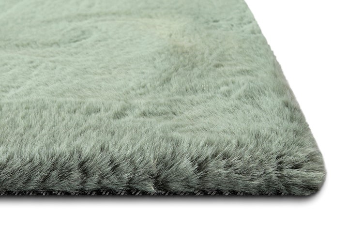 Nahaufnahme eines weichen Hochflor-Teppichs in hellem Grün mit dichter Textur.