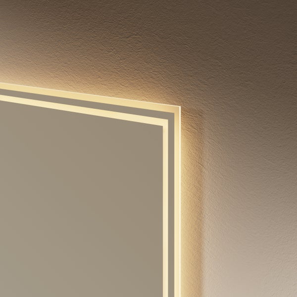 Detailaufnahme der Ecke eines beleuchteten Spiegels mit zwei Lichtstreifen vor einer strukturierten Wand.