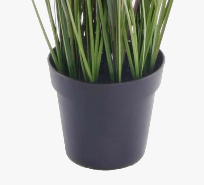 Künstliches Gras im schwarzen Kunststofftopf.