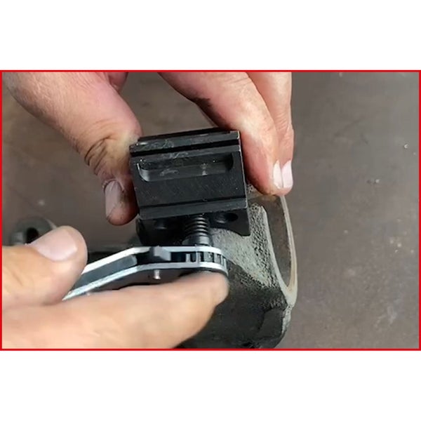 Hand mit Schutzhandschuh bedient digitalen Drehmomentschlüssel an einem Regal