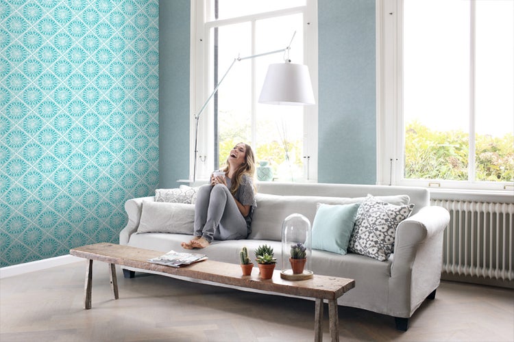 Heller Wohnraum mit gemusterter Tapete, Sofa und Holztisch