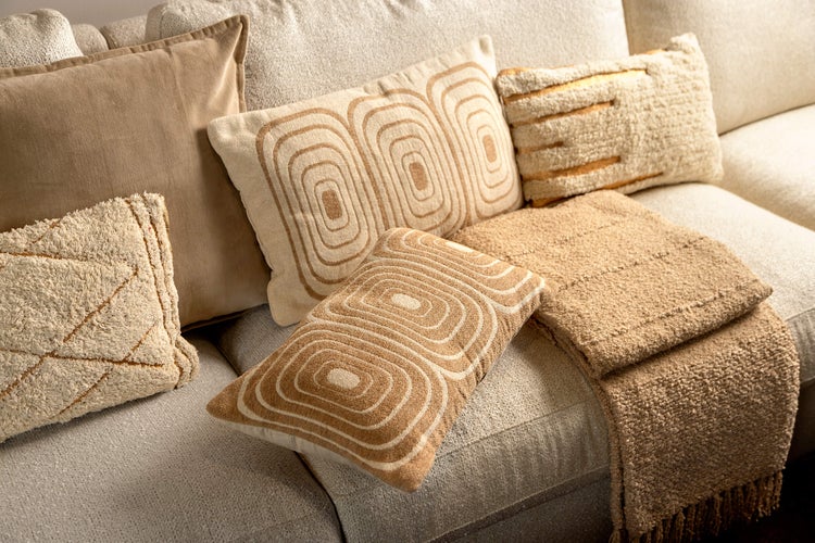 Dekorative Kissen und Decke auf einem Sofa