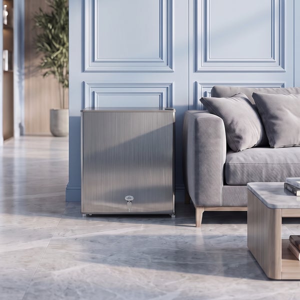 Kompakte Minibar oder Minikühlschrank in Metalloptik mit Schloss, platziert neben einem Sofa im modern eingerichteten Wohnzimmer.