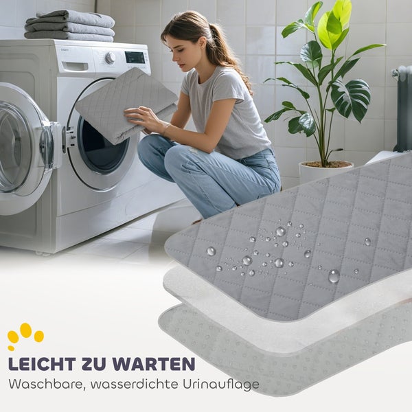 Eine Frau legt eine waschbare, wasserdichte Urinauflage in eine Waschmaschine. Die gesteppte Matte wird im Detail mit Wassertropfen gezeigt.