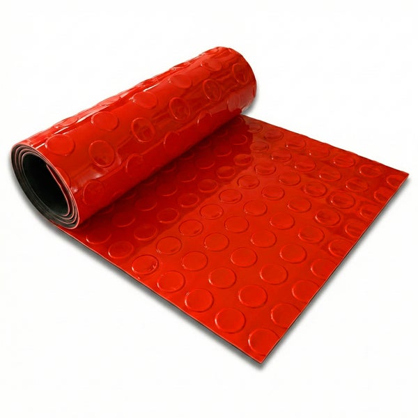Rote Gummimatte mit Noppen teilweise aufgerollt.