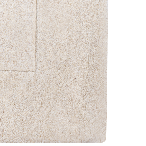 Cremefarbener Teppich mit weichem Flor und gewebter Rückseite.