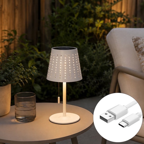 Moderne LED Tischleuchte für den Außenbereich mit Solarpanel und USB Kabel auf einem Beistelltisch im Garten.