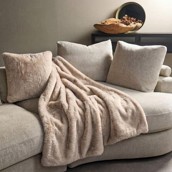 Gemütliche Szene mit einem Sofa, Kissen und einer weichen Decke