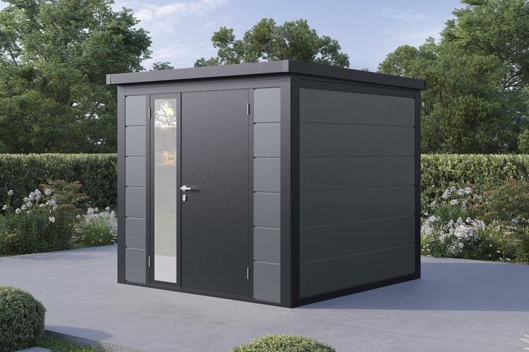 Modernes Gartenhaus aus Metall mit Flachdach, Einzeltür mit Glaseinsatz und Lüftungsschlitzen auf einer Terrasse in einem Garten.