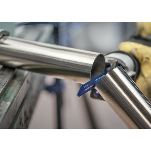 Ein Mann im Bauarbeiteroutfit befestigt mit einem Bolzensetzgerät von Fischer eine Metallschiene am Boden.