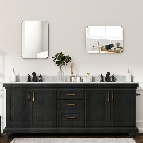 Wohnzimmer mit Spiegel, Bildern und dekorativen Objekten auf einem Sideboard.