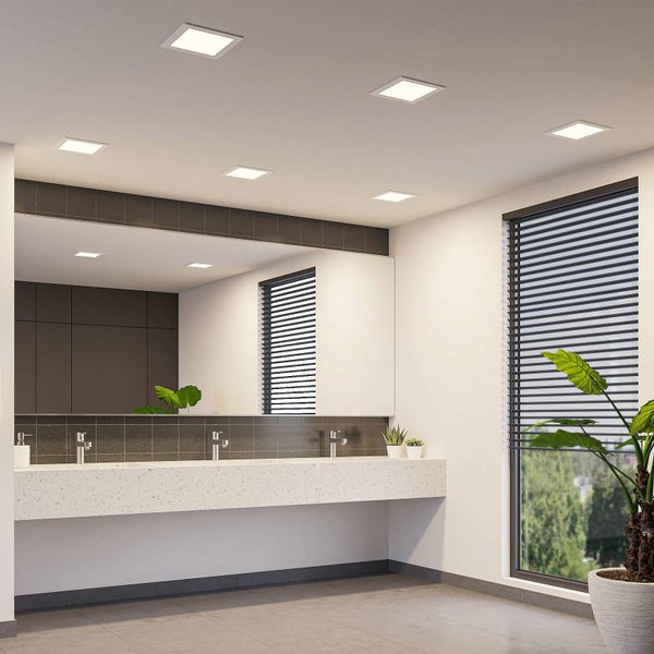 Moderne Badezimmer-Szene mit mehreren quadratischen LED-Einbaustrahlern an der Decke, einem langen Waschtisch und einem großen Spiegel.