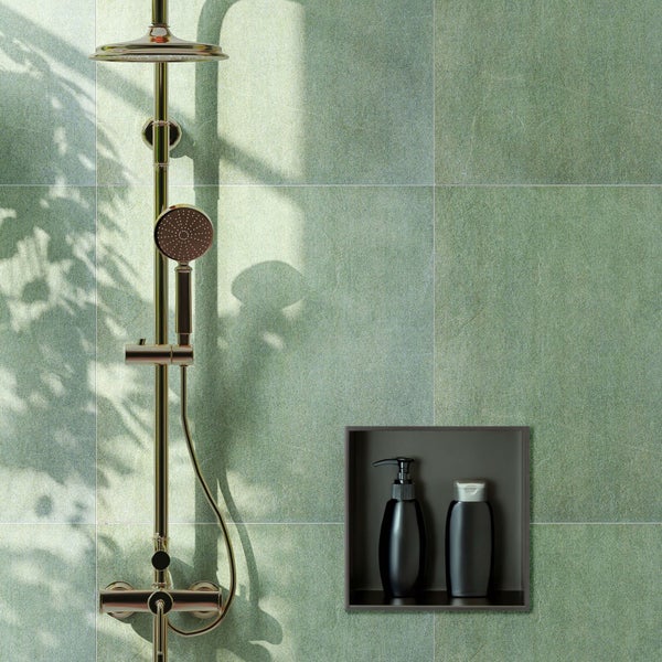 Duschsystem mit Regendusche und Handbrause in Goldoptik, montiert an einer Wand mit grünen Fliesen in Steinoptik und einer Einbaunische.
