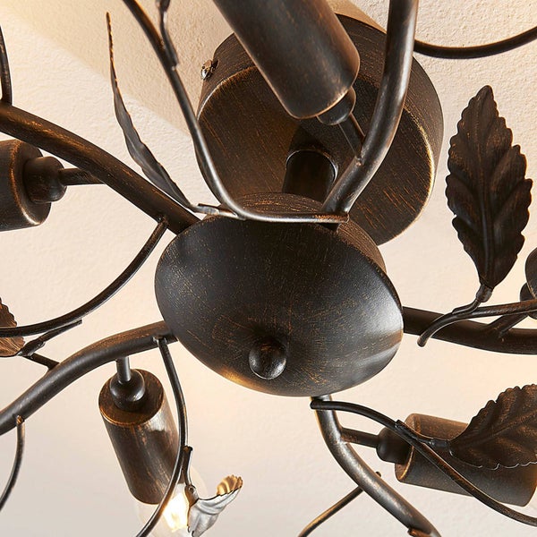 Detail einer Deckenleuchte mit Ästen und Blättern aus Metall im antiken Stil.
