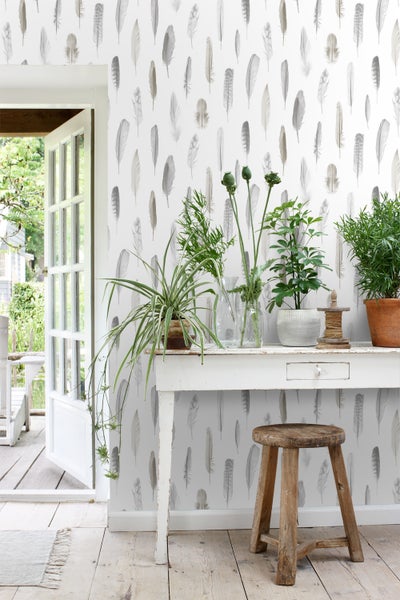 Heller Raum mit Feder-Tapete, Tisch und Pflanzen