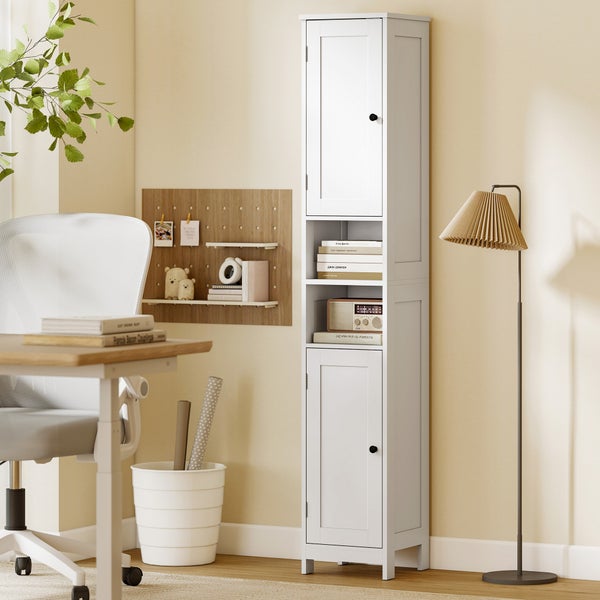 Hoher weißer Mehrzweckschrank mit zwei Türen und offenen Regalfächern in einem hellen Arbeitszimmer neben einem Schreibtisch und einer Stehlampe.