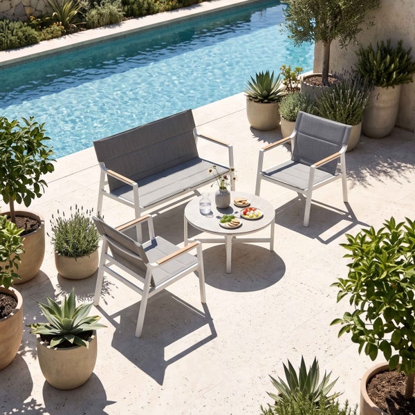 Modernes Gartenmöbel-Set mit Sofa, zwei Sesseln und rundem Tisch auf einer hellen Terrasse am Pool, umgeben von Pflanzen in Töpfen.
