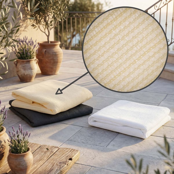 Zusammengelegtes Sichtschutzgewebe in Beige, Grau und Weiß auf einer sonnigen Terrasse mit Nahaufnahme der Gewebestruktur.