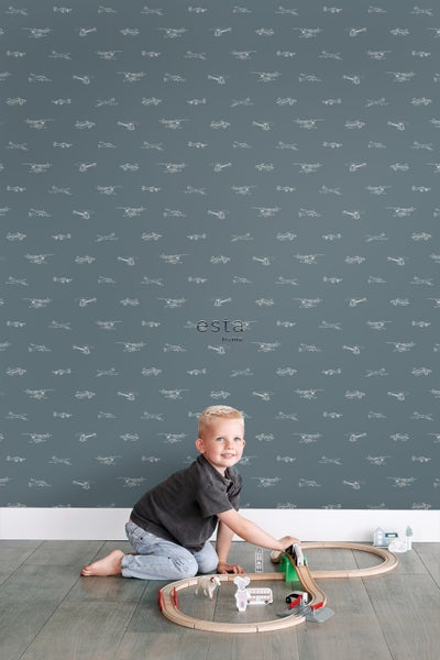 Zimmer mit Esta Home Tapete mit Flugzeugmuster und spielendem Kind