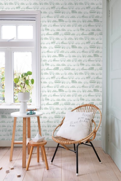 Dekoratives Zimmer mit Tapete mit Fahrzeugmuster, Sessel und Beistelltisch