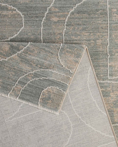 Blau-grauer Kurzflor-Teppich mit abstraktem Linienmuster, Detailansicht mit umgeschlagener Ecke und sichtbarer Rückseite.