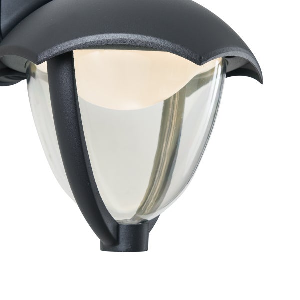 Dunkelgraue Außenwandleuchte aus Metall mit kegelförmigem Glasdiffusor und eingeschaltetem Leuchtmittel.