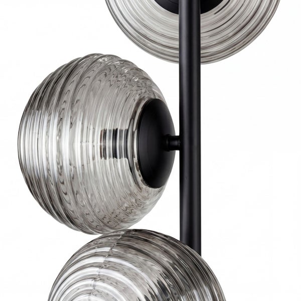 Moderne Leuchte mit schwarzem Metallgestänge und kugelförmigen Glasschirmen aus geriffeltem Klarglas.