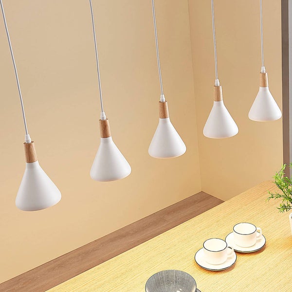 Mehrere Pendelleuchten mit Holzdetail hängen über einem Tisch