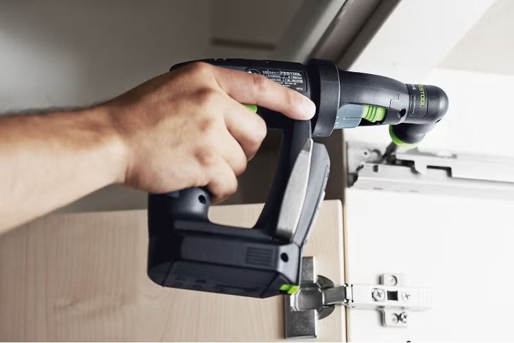 Festool Akku-Bohrschrauber mit Winkelaufsatz bei der Montage eines Scharniers im Schrank.