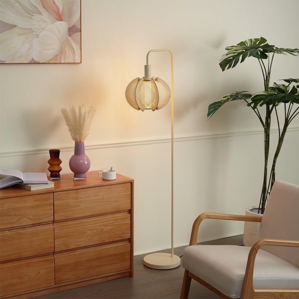 Moderne Stehleuchte mit kugelförmigem Lampenschirm in hellem Wohnzimmer mit Holzkommode, Pflanze und Sessel.