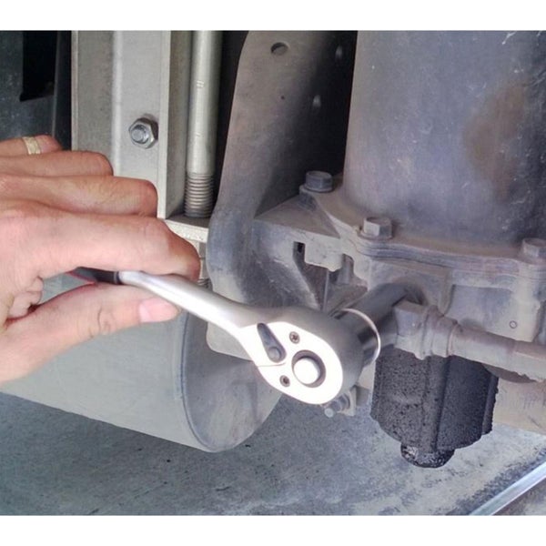 Eine Hand bedient eine Umschaltknarre an einem mechanischen Bauteil eines Fahrzeugs.