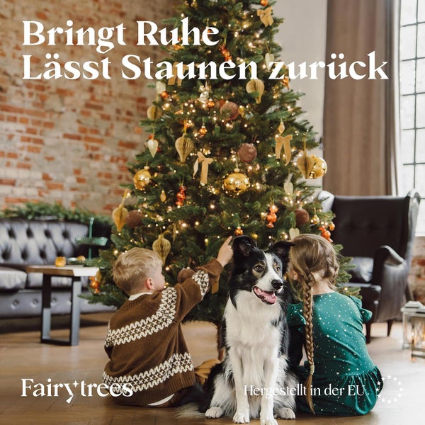 Ein geschmückter Weihnachtsbaum mit Kindern und einem Hund in einem Wohnzimmer mit Ziegelwand.