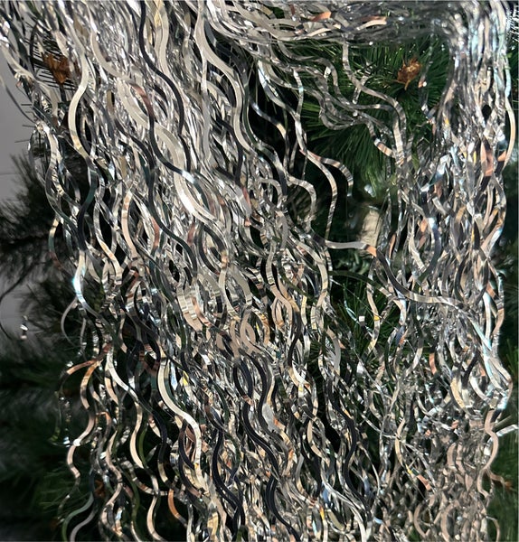 Silberne Lametta Girlande als Weihnachtsdekoration auf einem Weihnachtsbaum.