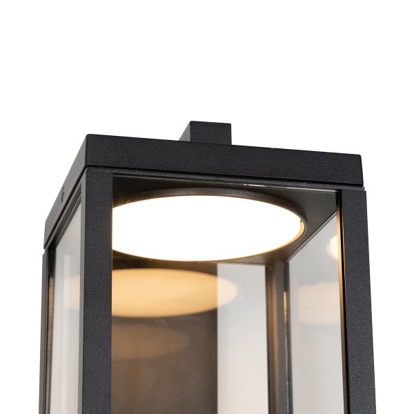 Schwarze Außenleuchte in Laternenform aus Metall und Glas mit integriertem LED-Modul.