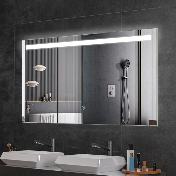 Rechteckiger Badezimmerspiegel mit LED Beleuchtung und Touch Sensor an einer dunklen Fliesenwand über einem Doppelwaschbecken.