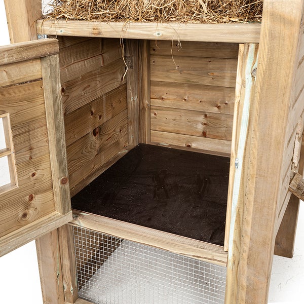 Detailansicht des Holzlegeplatzes mit geöffneter Tür, Einblick ins Innere mit Bodenschutz und darüberliegendem Heu