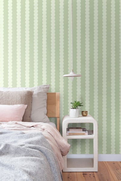 Schlafzimmer mit Bett, Nachttisch und Tapete mit Punktmuster