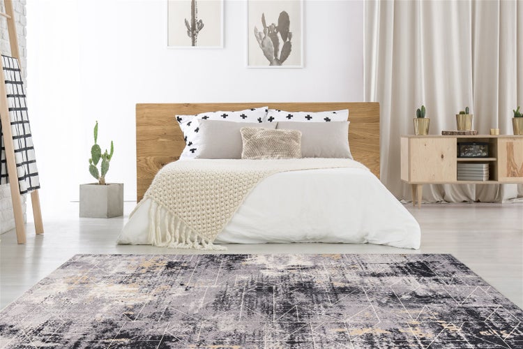 Ein moderner, gemusterter Teppich in einem stilvoll eingerichteten Schlafzimmer mit einem Holzbett und hellen Wohnaccessoires.