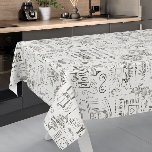Tischdecke mit Kaffee-Motiven und Schriftzügen in einer modern eingerichteten Küche.