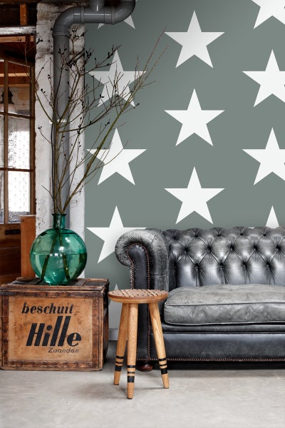Wohnzimmer mit Sofa, Hocker, Dekoration und Tapete mit Sternmuster