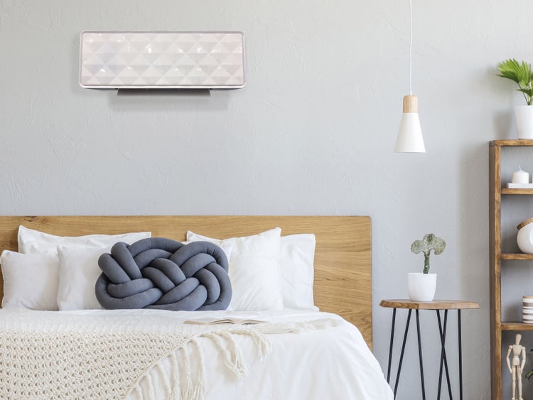 Schlafzimmer mit Klimaanlage, Bett und Nachttisch