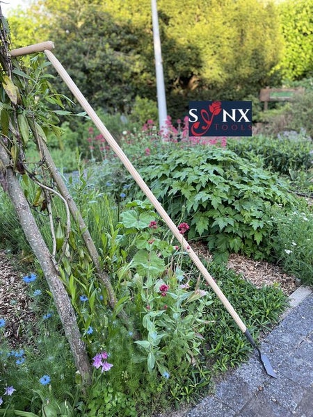 Bodenhacke mit Holzstiel im Garten