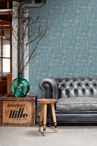 Wohnzimmer mit Sofa, Hocker, Holzkiste und Tapete mit Flugzeugmotiven