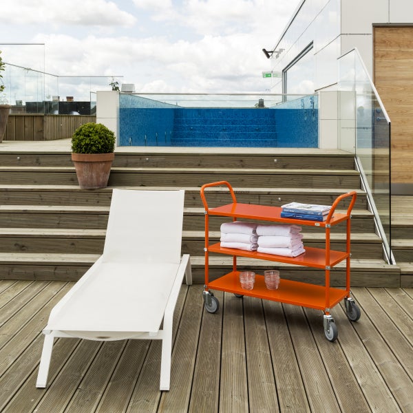 Szene mit Pool auf einer Holzterrasse mit Liegestuhl und Servierwagen